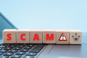 Wooden blocks spelling "scam"